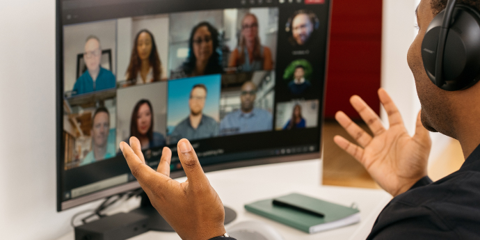 A man is speaking to his colleagues in a virtual meeting. 