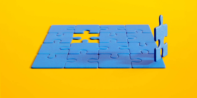 An animated puzzle piece jumps out of a puzzle, then circles back to rejoin the puzzle.