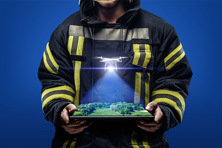 Image shows a firefighter gazing down at his laptop and seeing a three-demnsional image of drone footage, showing how Teams connectivity aids search-and-rescue missions 